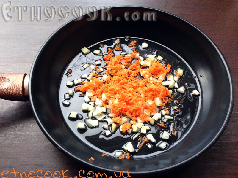 Для приготування Спаржевої квасолі за традиційним українським рецептом від кулінарного блогу країнська етнічна кухня Етнокук підсмажуємо цибулю з морквою в олії до золотистого кольору
